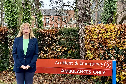 Liz Jarvis stand infront of Royal Hampshire County Hospital Accident and Emergency sign